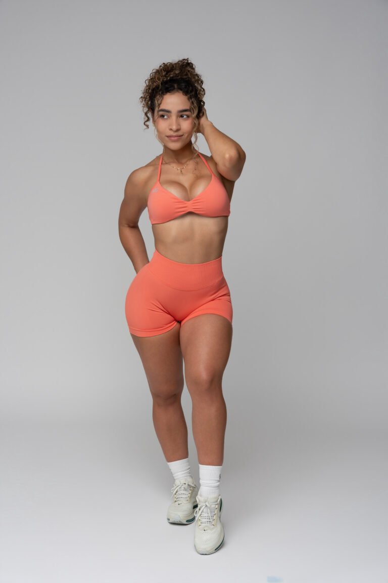 Woman in a peach MG Wear bikini, front view, studio.
